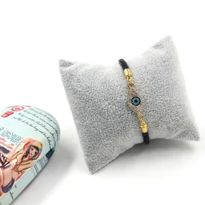 Détail du bracelet tressé œil grec avec cristaux étincelants sur un coussin en velours
