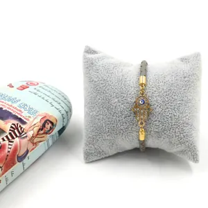 Détail du bracelet main de Hamsa avec œil bleu et strass brillants sur cordon gris