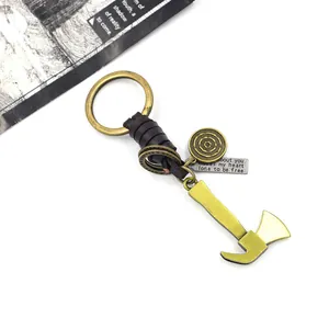 Close-up of vintage bronze axe keychain with leather weave and engraved quote tag