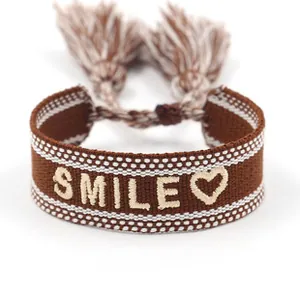 Detail of embroidered leopard print heart bracelet with smile text and tassels