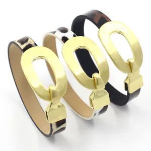 Dettaglio di tre bracciali in pelle animalier con fibbie ovali in metallo dorato opaco