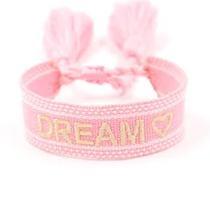 Bracciale dell'amicizia intrecciato rosa con ricamo DREAM dorato e nappine