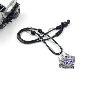 Macro detail of punk Evil Eye pendant with skull motifs on a layered biker rope necklace