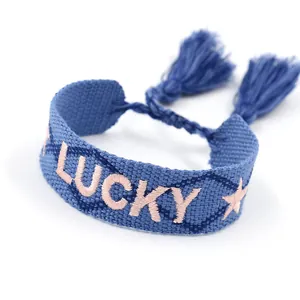 Pulsera de la amistad tejida azul con texto Lucky bordado en rosa y borlas decorativas