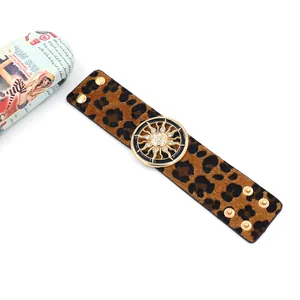 Detail of leopard print faux fur cuff bracelet with golden sunburst rhinestone accent
