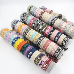 Detailed close-up of colorful embroidered friendship bracelets with tassels and words