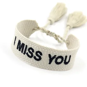 Minimalist cream woven couple bracelet featuring black I MISS YOU embroidery and tassels