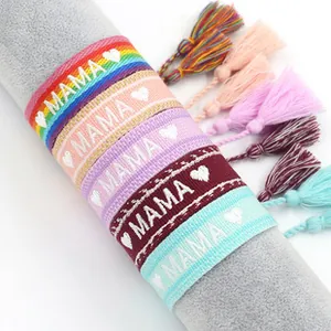 Detail of bohemian woven MAMA friendship bracelets with heart patterns and silk tassels