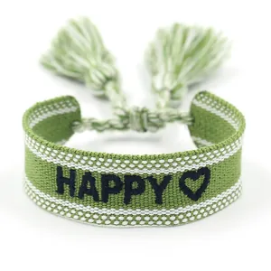 Handmade woven friendship bracelet with green white pattern and black HAPPY embroidery