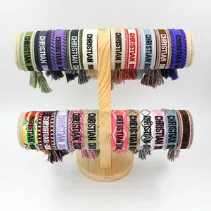 Detail of colorful woven tassel bracelets with bohemian embroidery and logo patterns