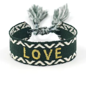 Ethnic woven bracelet with LOVE gold embroidery, green tassel, and bohemian style