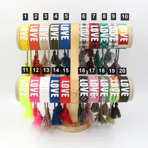 Set of 20 braided LOVE embroidery friendship bracelets with tassels on a display stand