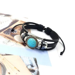 Macro detail of multi-layer leather bracelet with turquoise bead and metallic accents