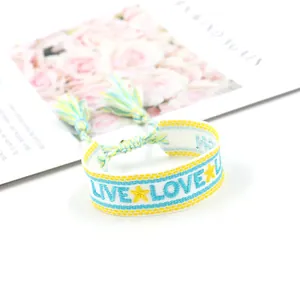 Handgefertigtes gewebtes Stickarmband mit Live Love Schriftzug und gelben Quasten