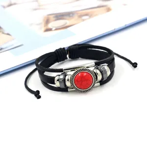 Detail of bohemian multilayer black leather bracelet with red turquoise bead and silver accents