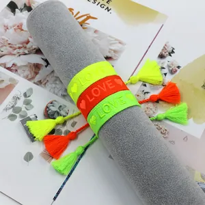 Detail von gewebten Stickarmbändern in Neonfarben mit Herz- und LOVE-Schriftzug