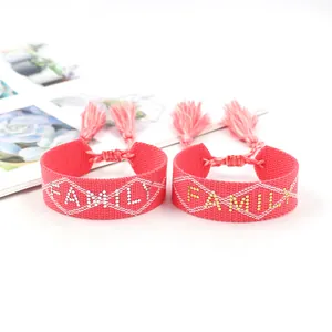 Pink woven bohemian friendship bracelets with family lettering and decorative tassels