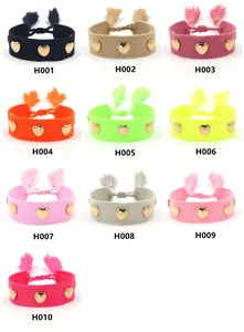 Close-up of heart-studded woven bracelets in multiple colors with tassel drawstrings