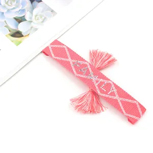 Pink woven friendship bracelet with silver FAMILY sequin lettering and fringe tassels