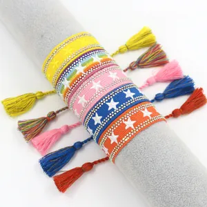 Bracciali boho intrecciati colorati con stelle di strass e nappe su un espositore