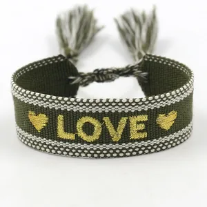Pulsera boho verde oliva con bordado LOVE dorado y elegantes detalles de borlas