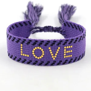 Pulsera tejida morada hecha a mano con texto LOVE amarillo y flecos elegantes
