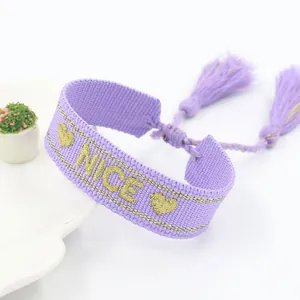 Handmade purple woven bracelet with gold NICE embroidery and adjustable tassels