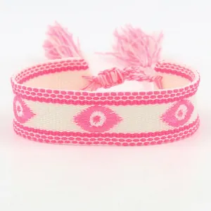 Gedetailleerde opname van handgeweven roze evil eye armband met decoratieve kwastjes