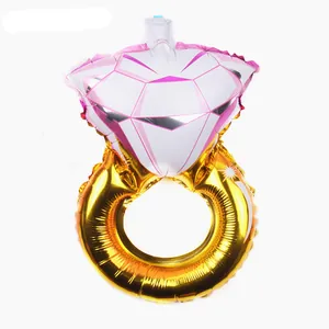Detailed view of large golden diamond ring foil balloon with pink accents for parties