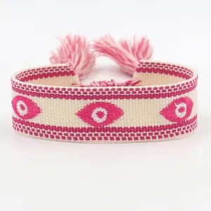 Handgeweven Evil Eye armband met roze kwastjes en bohemian borduurwerk details