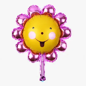 Detail of sunflower foil balloon with smiley face and pink petals for party decor