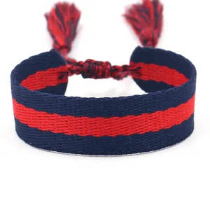 Pulsera tejida étnica con rayas rojas y azules, borlas y nudo trenzado ajustable