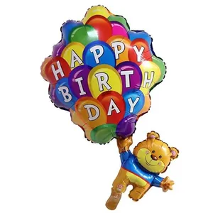 Detail of colorful Happy Birthday foil balloons with a cute flying cartoon bear charm