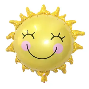 Close-up of a large sun-shaped foil balloon with a cartoon face for party decorations