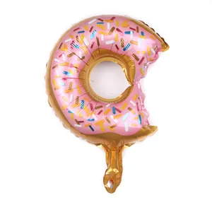 Detail shot of a donut foil balloon with pink frosting, colorful sprinkles, and a bite mark