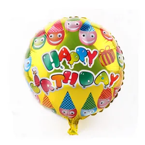 Detail of yellow round Happy Birthday foil balloon with colorful smiles and party hats