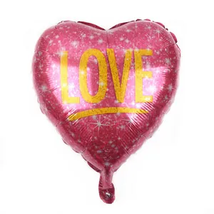 Détail d'un ballon coeur magenta avec paillettes et lettrage LOVE doré élégant