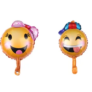 Detail of two fun Emoji foil balloons featuring a girl with bow and a festive hat design