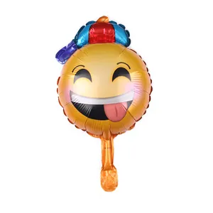 Close-up of a yellow emoji balloon with a colorful party hat and playful expression