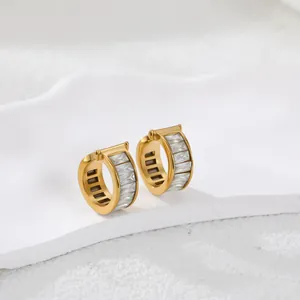Detail van gouden oorringen met baguette-geslepen zirkonia en verfijnd opengewerkt design