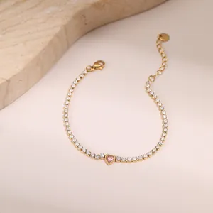 Detalle de una pulsera tenis dorada con piedra de corazón rosa y circonitas blancas