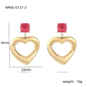 Détail de boucles d'oreilles cœur dorées avec zircon rouge et mesures de taille précises