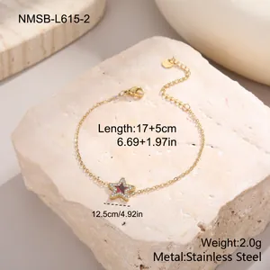 Detail eines 18K vergoldeten Edelstahlarmbands mit Sternanhänger, rotem Inlay und Steinen