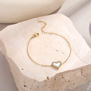 Bracelet cœur doré élégant avec incrustation de nacre et cristaux sur fond de pierre