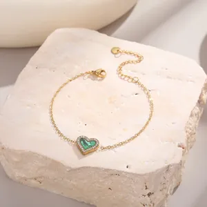 Détail du bracelet coeur doré avec pierre verte et cristaux pavés sur la pierre