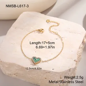 Détail du pendentif cœur avec pierre verte sur bracelet en acier doré