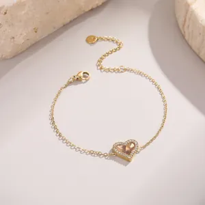 Bracelet doré avec pendentif cœur pavé de zircons sur décor de pierre élégante