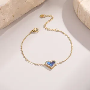 Détail macro du bracelet cœur doré avec émail bleu et bordure scintillante en zircon