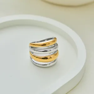 Macro-opname van een dikke tweekleurige gelaagde ring met goud en zilver finish