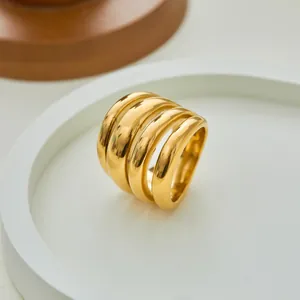Detailweergave van goudkleurige spiraalring met meerdere lagen op een witte standaard